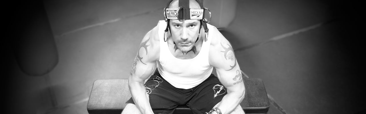 Person sitting on a bench with a serious expression in a gym setting