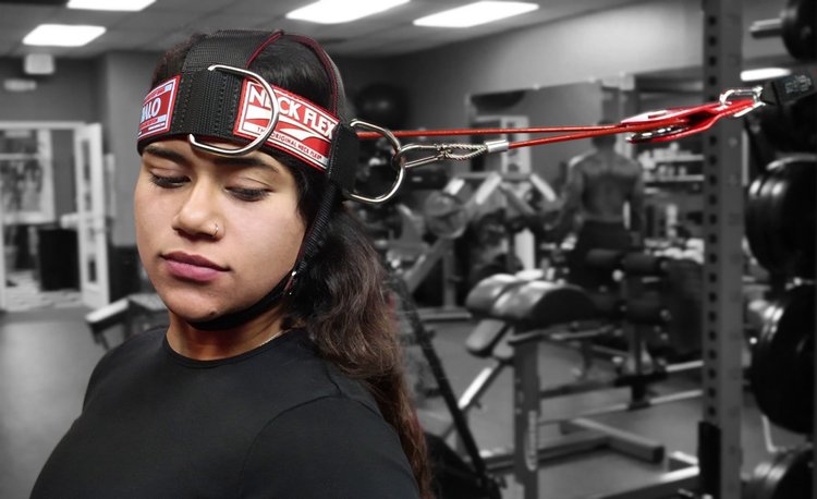 Athlete training with the Neck Flex HALO neck harness and Revolver attachment with a resistance band in a gym